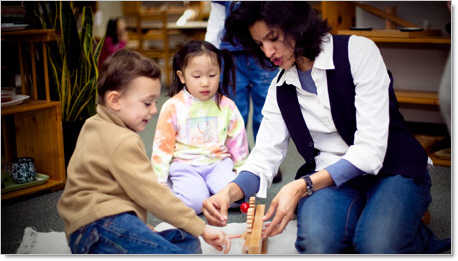 montessori teacher working with 2 preschool students 